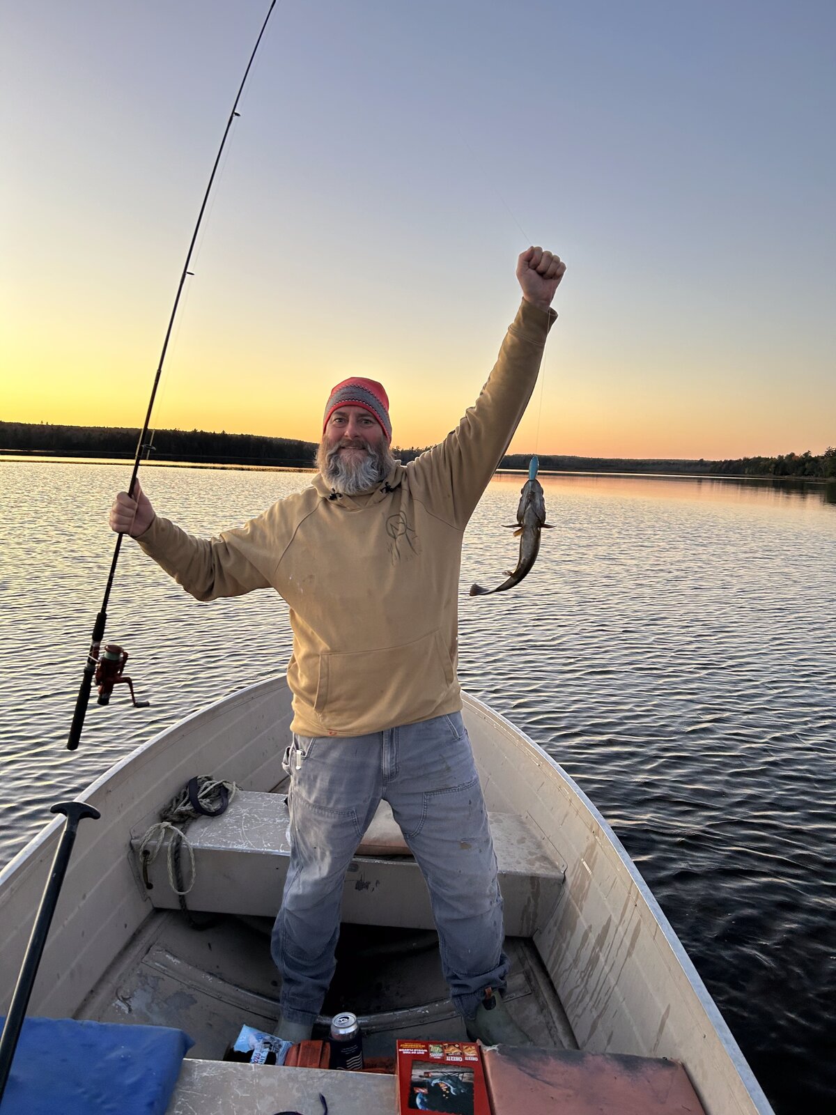 Angler celebrating a catch at sunset on Molunkus Lake
