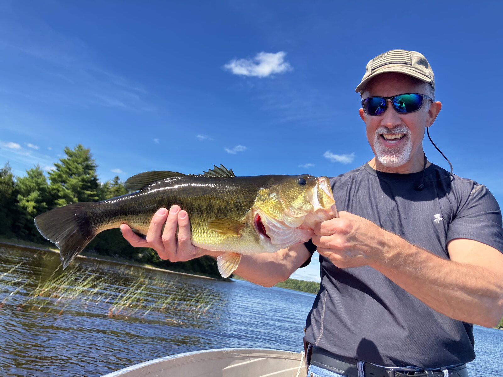 Guest holding a bass caught on Molunkus Lake