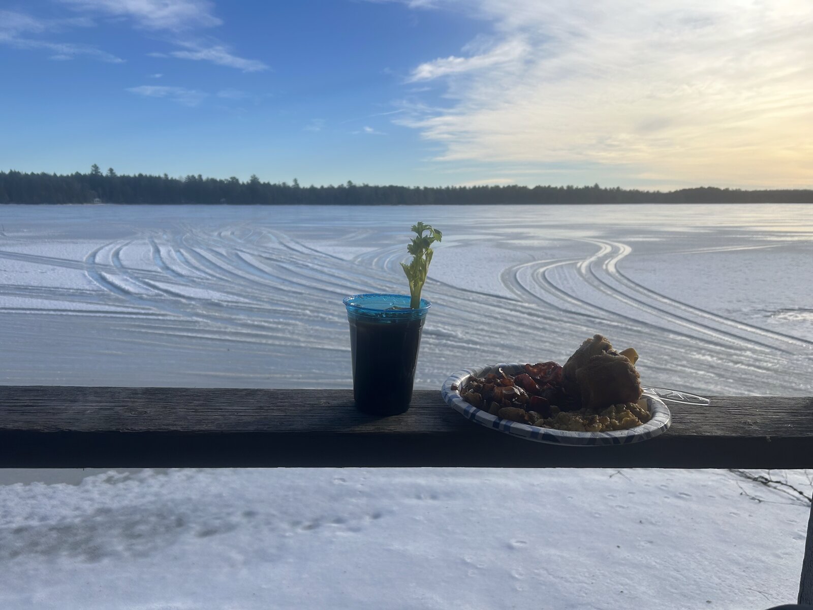 Frozen Molunkus Lake in winter with snowmobile tracks