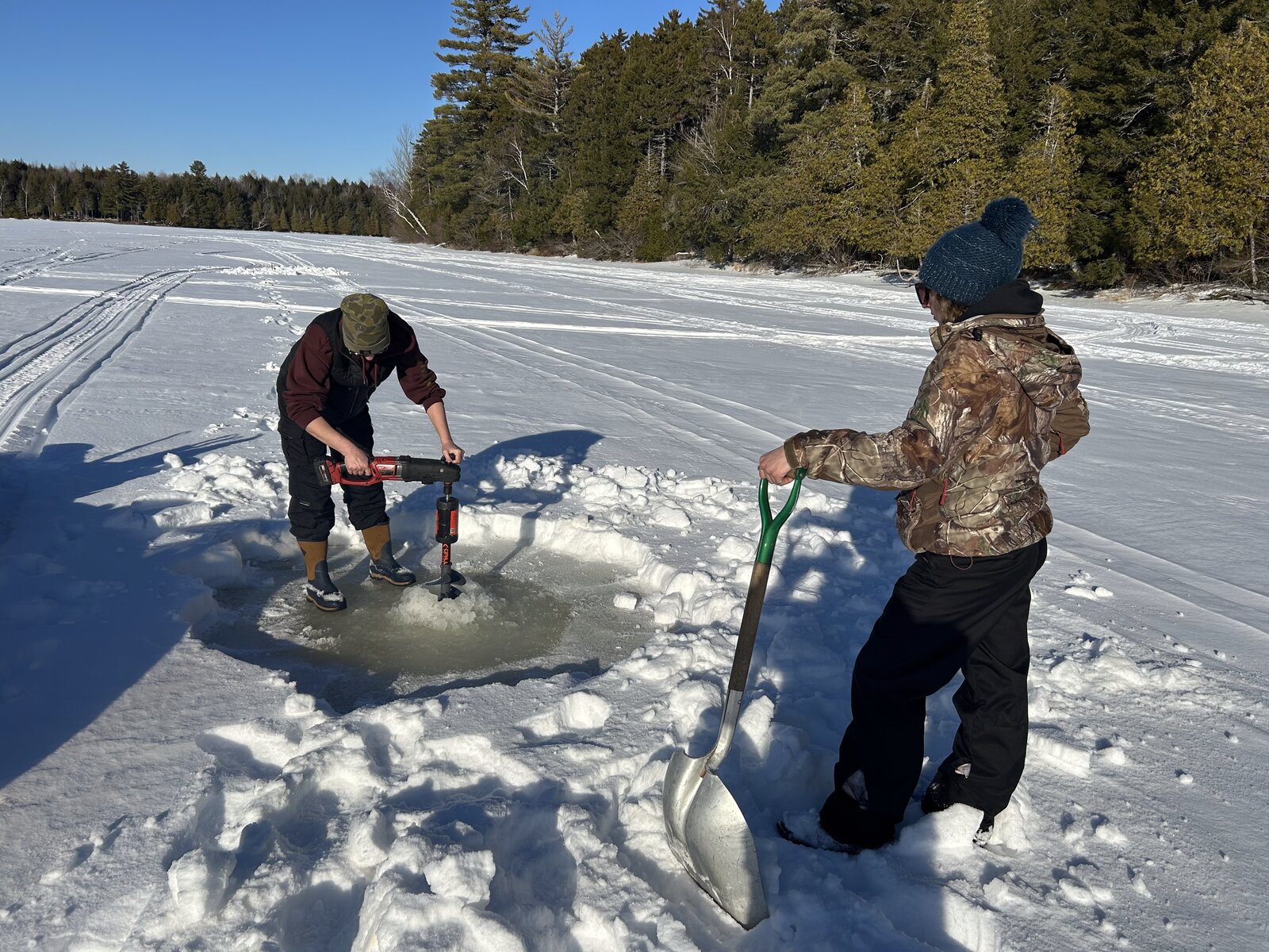 Drilling an ice fishing hole on frozen Molunkus Lake