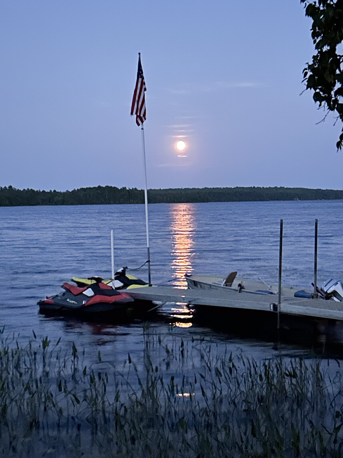 Jet skis at the Molunkus Lake dock under a full moon