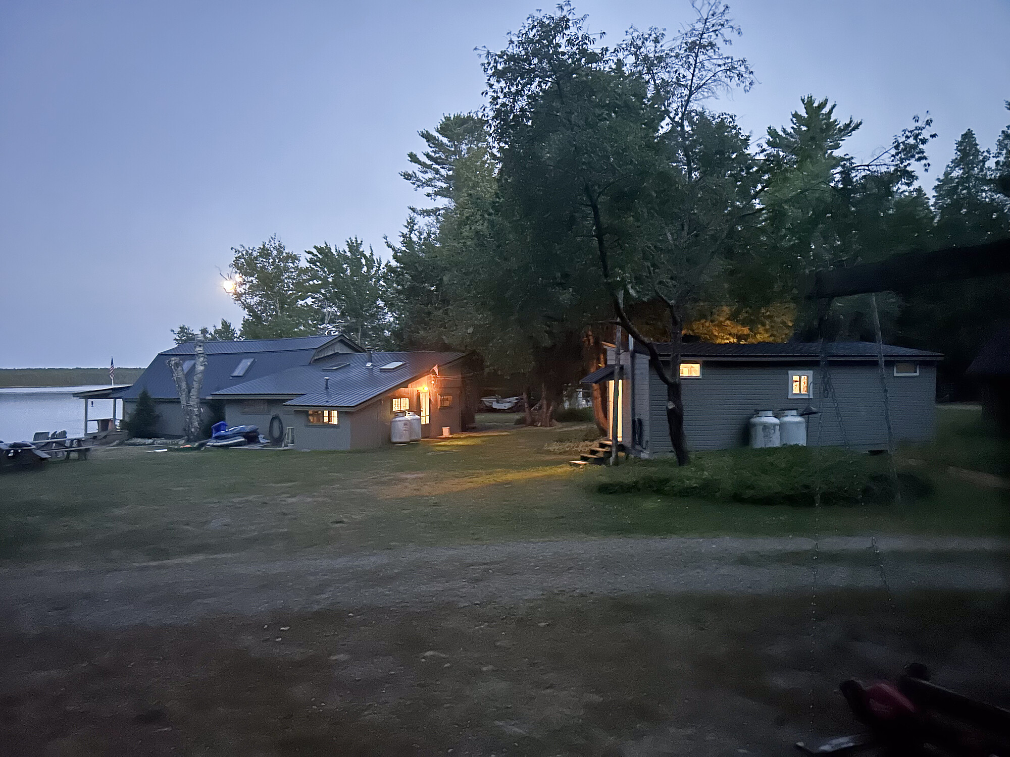The main lodge at Molunkus Lake Sporting Camps at dusk, windows glowing